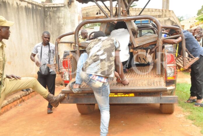 Some of the homosexuality suspects board a police vehicle following their arrest at a massage parlour in Buikwe District on August 20, 2023. Clinton Mirrors Reported